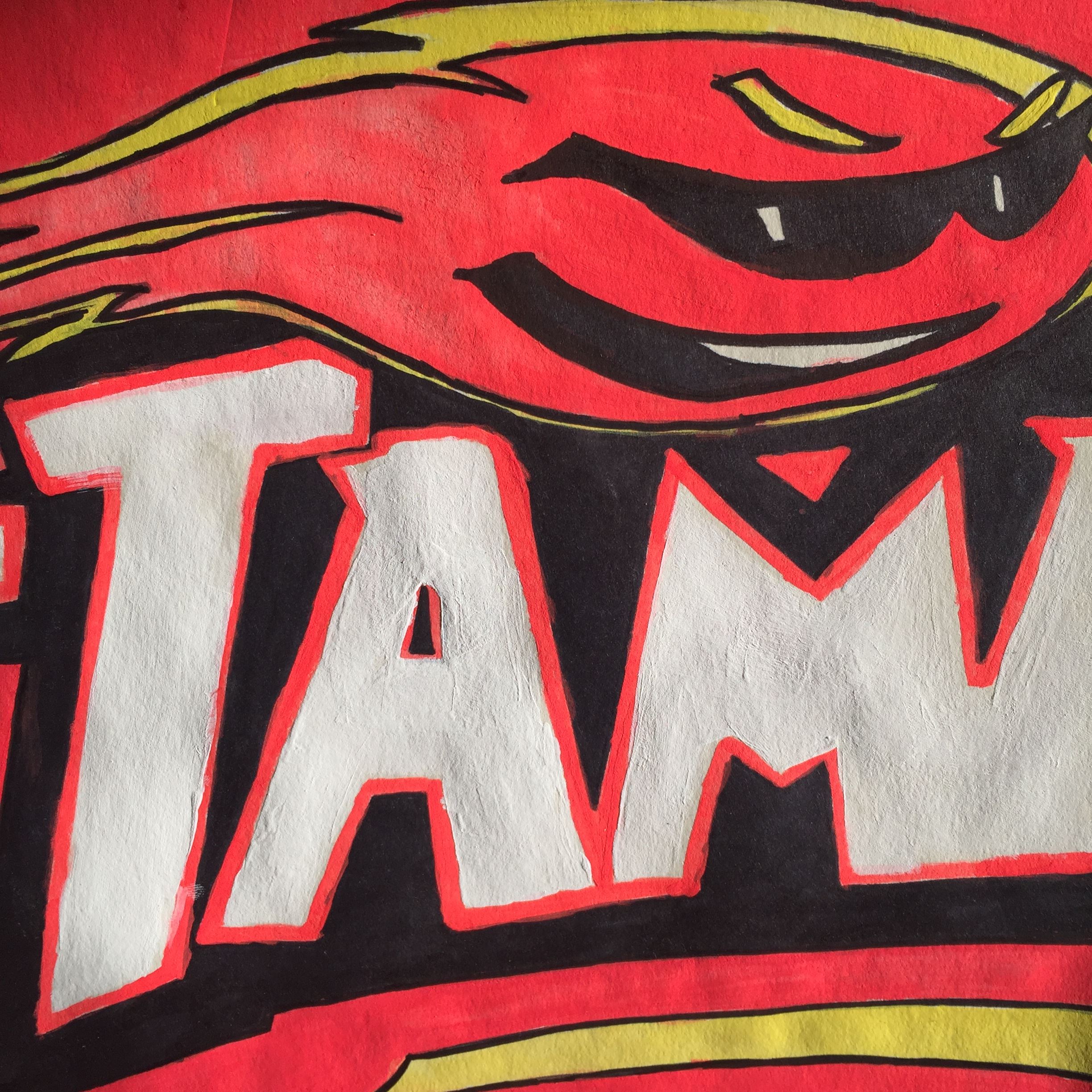 Red, black and white painting of the letters T.A.M 